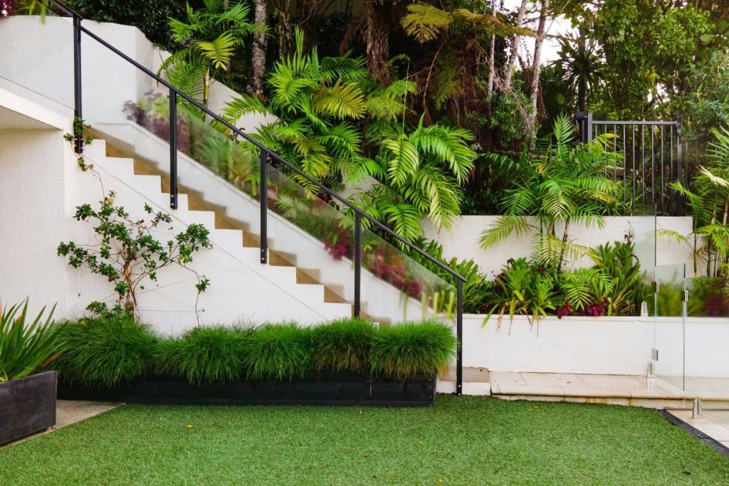 Diseño de jardín con césped natural y plantas ornamentales en terraza.